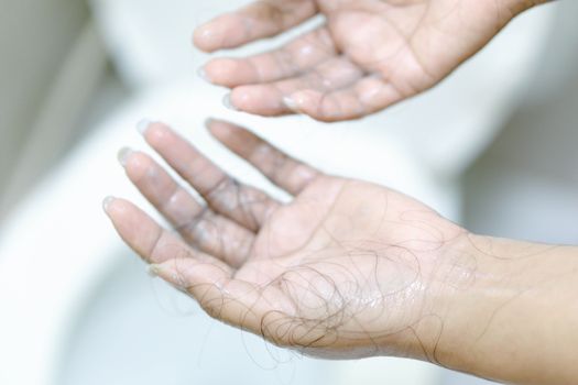 Closeup Hair loss on woman hand in the bathroom