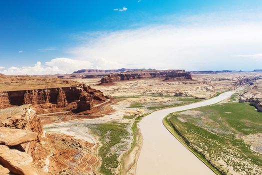 Hite overlook on route UT-95 shows rocky cliffs and valley in Glen Canyon National Recreation Area with flowing Colorado river. Utah, USA