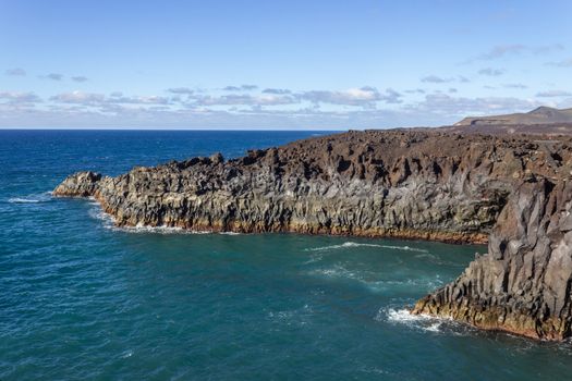 Rocky coastline Los Hervideros in the south west of canary island Lanzarote, Spain with rough sea, lava caves and multi colored volcanic rocks