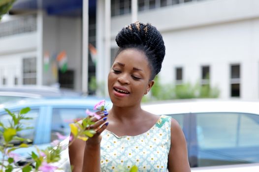 smiling young woman holding a flower and playing with it.