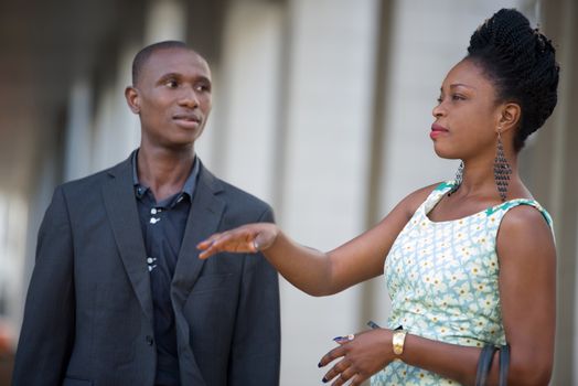 young business people standing together discuss their work where the man looks attentively at his colleague.