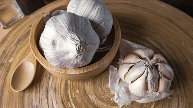 The garlic in wood bowl  on wood table for food content.