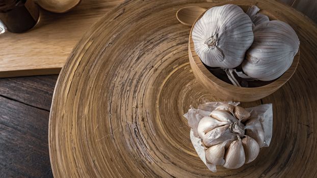The garlic in wood bowl  on wood table for food content.