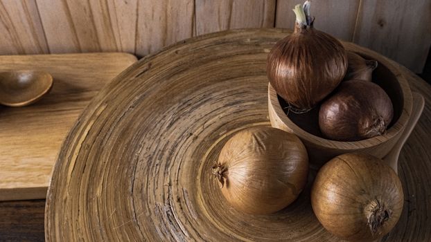 The onion in wood bowl  on wood table for food content.