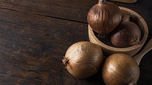 The onion in wood bowl  on wood table for food content.