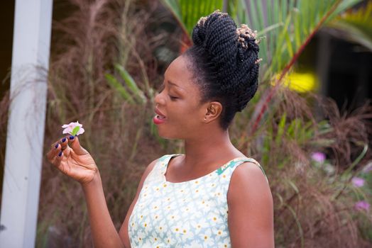 young happy businesswoman standing on the street and holding a white flower in the hand