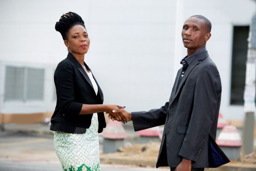 team of man and businesswoman shaking hands in the city