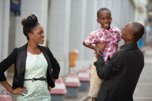 young happy couple with their child playing together on the street
