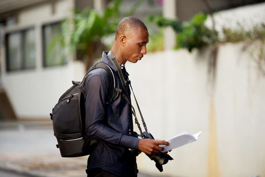 tourist man with map in hands explores the city in search of adventures.