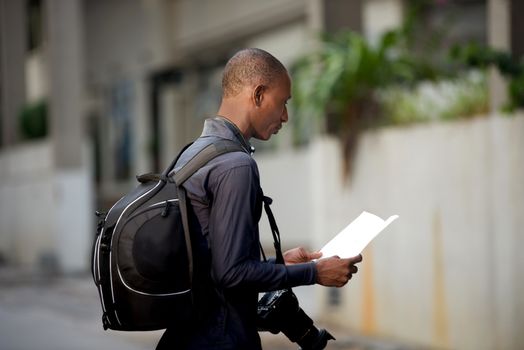 tourist man with map in hands explores the city in search of adventures.