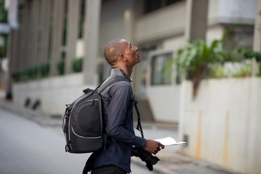 tourist man with map in hands explores the city in search of adventures.