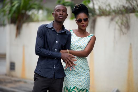 Couple of tourists posing together in front of camera in the street during their walk in town