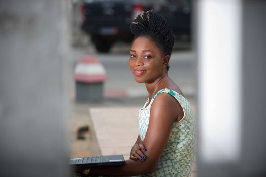 Close up of woman working on laptop sitting outdoors