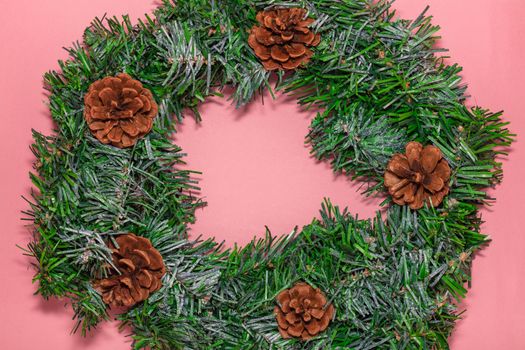 Top view of Christmas wreath on pink background. Christmas, new years celebration season concept.