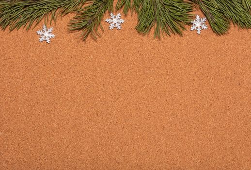 Empty corkwood notice board decorated with pine twigs and snowflakes. Christmas, new years celebration season, business concept.