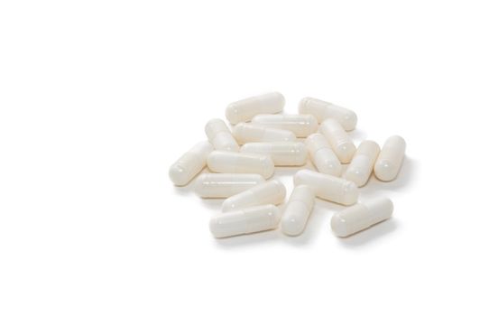 High angle close up shot of white pills isolated on white background with copy space. Pharmaceutical business and medicine sale concepts.