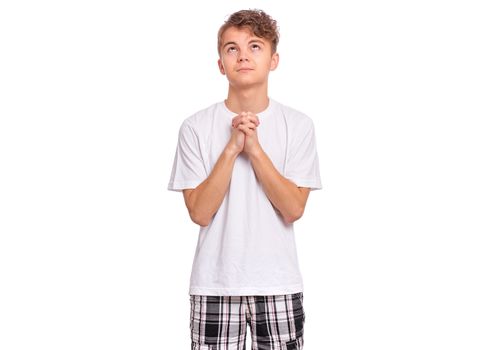 Handsome teen boy with hands folded in prayer hoping for better, isolated on white background