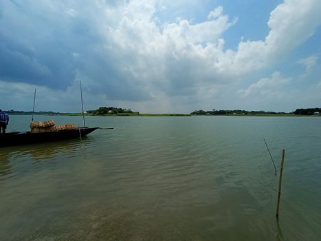 black colored wooden boat on river with sky