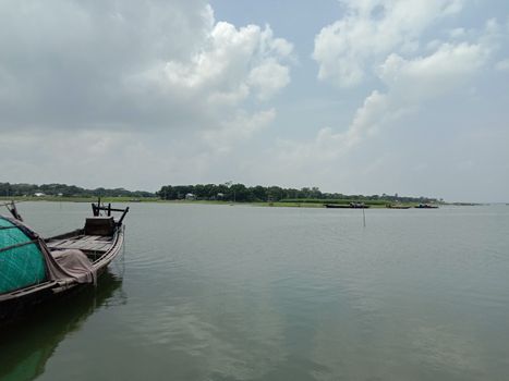 black colored wooden boat on river with sky