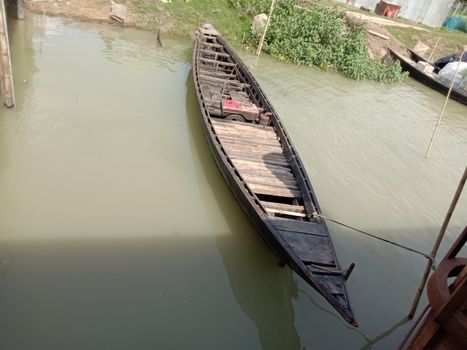 black colored wooden fishing boat on lake