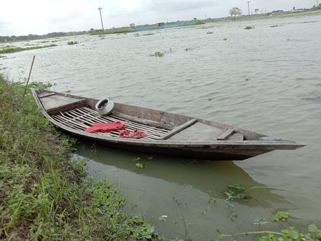 black colored wooden fishing boat on lake