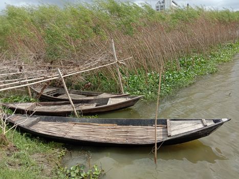 black colored wooden fishing boat on lake