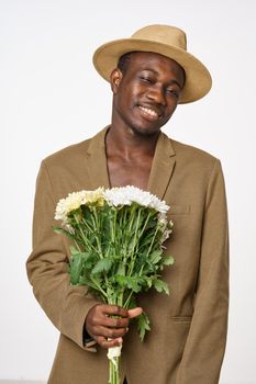 Man with a bouquet of flowers in a hat smile African appearance date romance