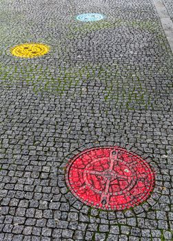 Pavement with colorful sewer covers in Porto, Portugal
