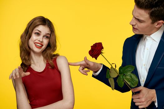 Young charming couple rose relationship romance gift as a lifestyle yellow isolated background. High quality photo