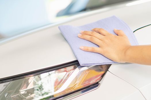 Man cleaning car with microfiber cloth, car detailing (or valeting) concept. Selective focus.