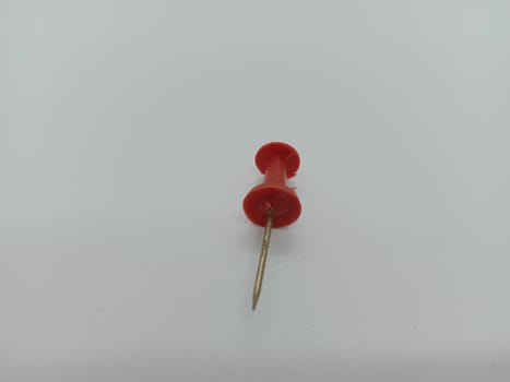 red colored push pin on white background