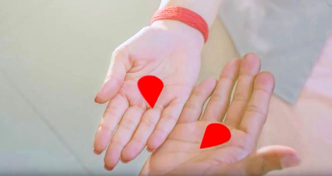 red colored divided love sign on man and woman's hand