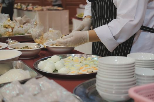 chef cutting boiled egg at restaurant