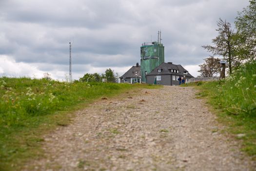 WINTERBERG, GERMANY - JUNE 7, 2020: People on a hiking trail crossing the peak of the Kahler Asten, most famous mountain of Sauerland region on June 7, 2020 in Germany