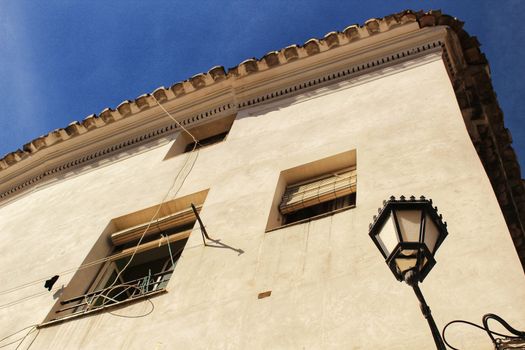 Old facade and streetlight in a small village of Castilla La Mancha community, Spain