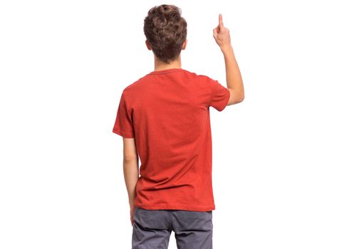 Handsome teen boy with his back turned to camera, pointing to something, isolated on white background
