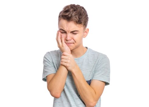 Handsome sad teen boy with tooth pain, isolated on white background