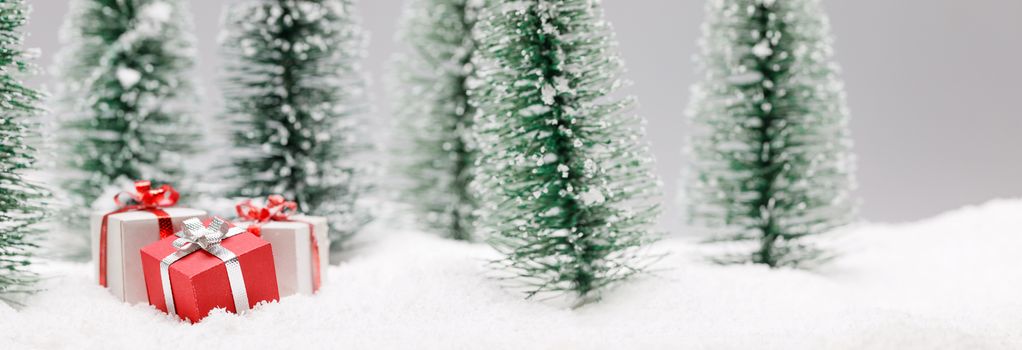 Christmas gifts in fir tree forest under snow