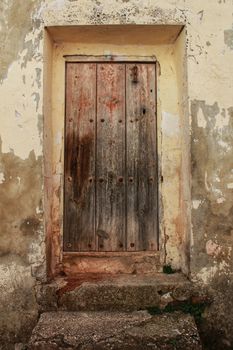 Old wooden door with wrought iron details in Villanueva de Los Infantes village, Spain