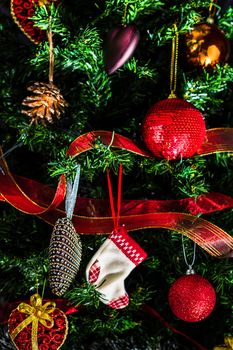 Christmas hanging decorations on fir tree. Decorated Christmas tree. Fir branch with Christmas baubles decorations.