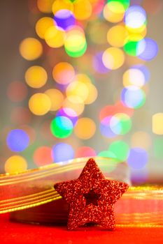 Red glittery decoration in a colorful Christmas composition isolated on background of blurred lights.