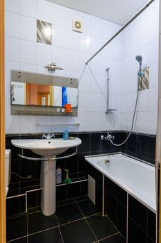 Classic bathroom interior in an apartment, with black and white tiles