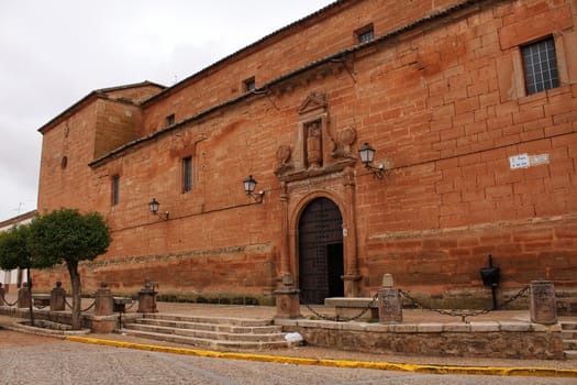 Old stone facade made of carved stone and vintage wooden door in a majestic house in Villanueva de los Infantes, Ciudad Real community, Spain. Encarnacion convent facade.