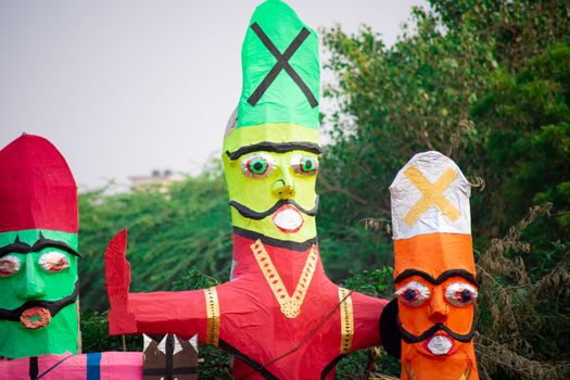 colorful ravana effigies placed on a busy street with traffic passing by to be purchased and filled with fireworks for the hindu festival of dussehra or vijay dashmi celebrating the victory of good over evil as given in the indian epic of ramayana