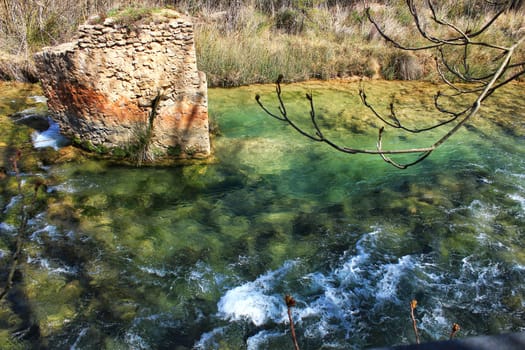 Cabriel River with crystal clear waters and surrounded by green vegetation in the mountains of Albacete, Spain