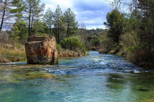 Cabriel River with crystal clear waters and surrounded by green vegetation in the mountains of Albacete, Spain