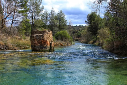 Cabriel River with crystal clear waters and surrounded by green vegetation in the mountains of Albacete, Spain