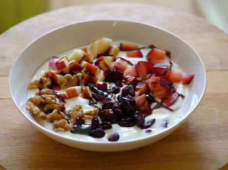 Bowl of yogurt with fresh fruits cubes nuts and silan