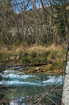 Cabriel River with crystal clear waters and surrounded by green vegetation in the mountains of Albacete, Spain