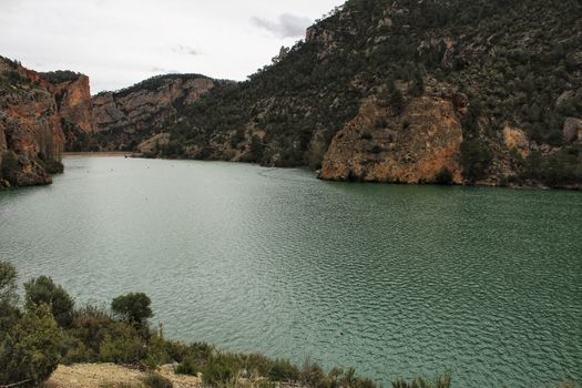 Swamp surrounded by mountains and colorful vegetation in El Molinar, Casas de Ves, Spain. Crystal Clear Waters of Cabriel River